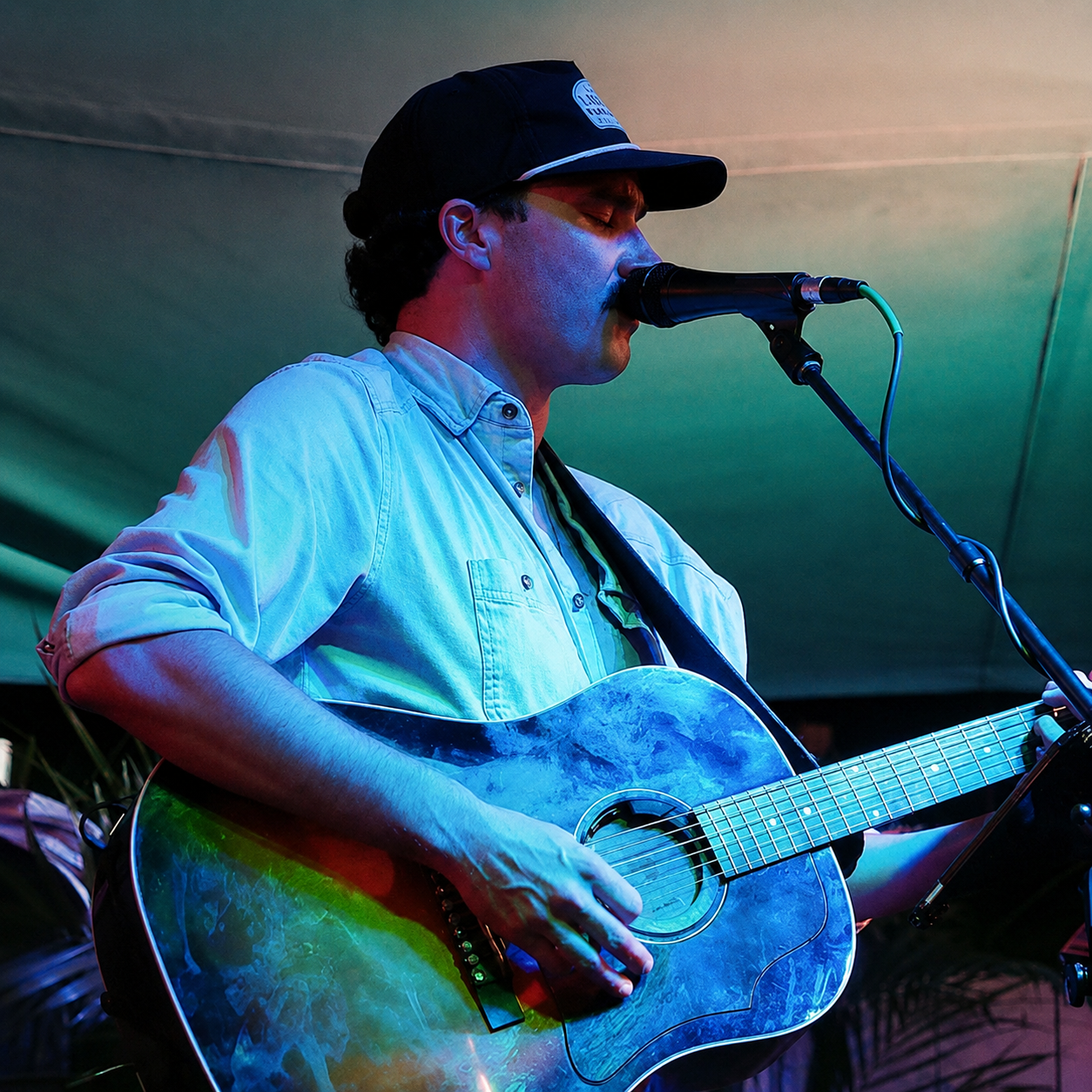 Guitarist and vocalist performing under stage lighting at Tonio's